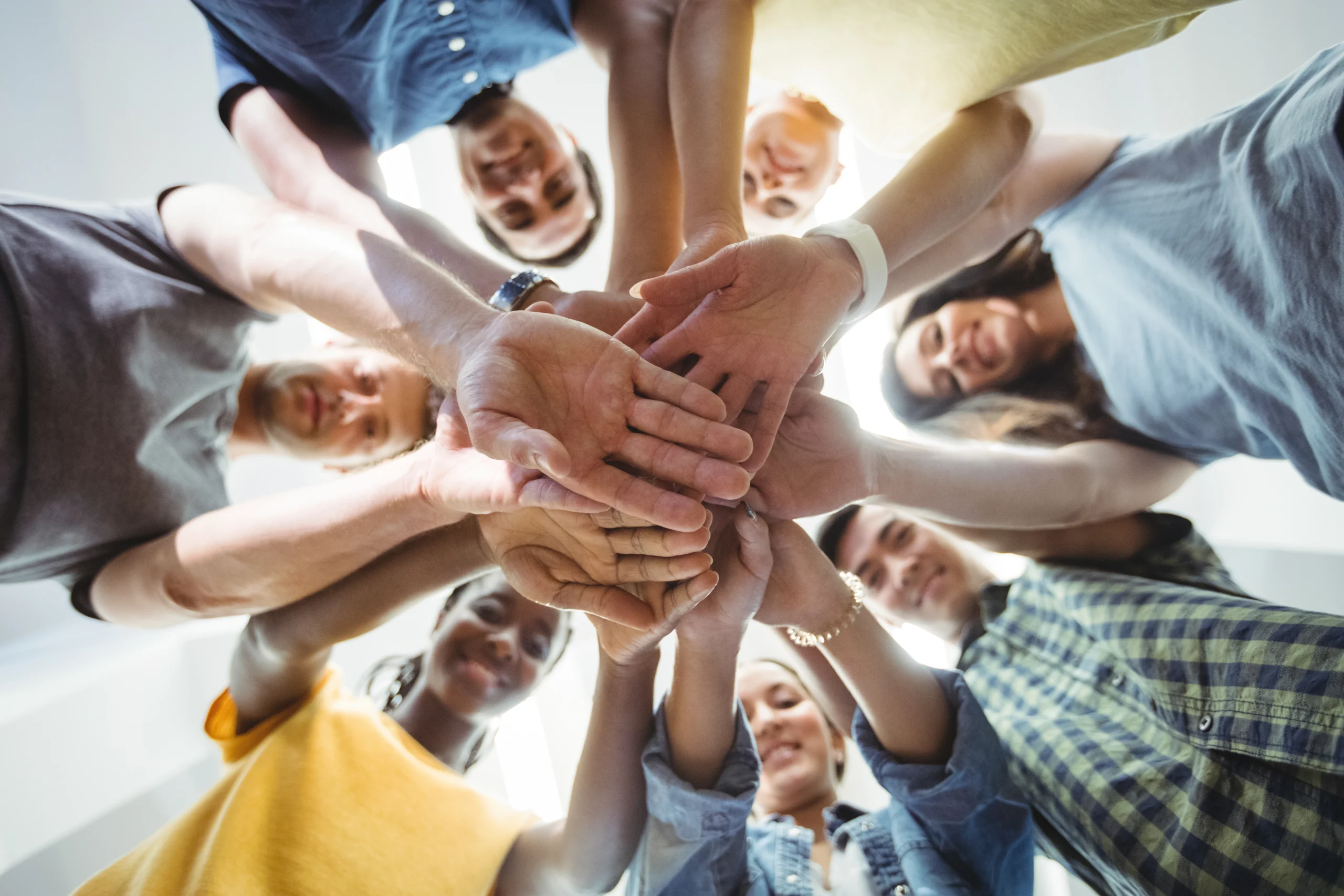 Groupe de personne souriant avec les mains joints