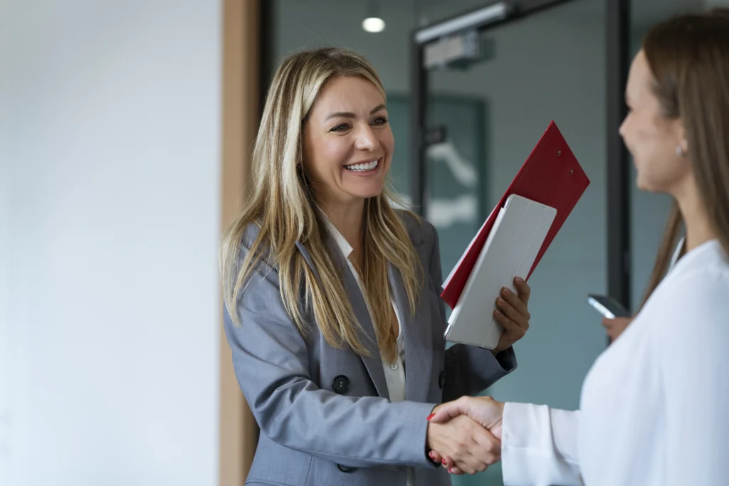 Femme souriante qui serre la main à une autre femme