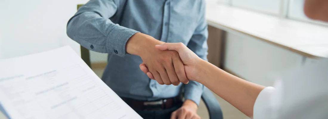 Homme qui serre la main à un femme qui tien un contrat
